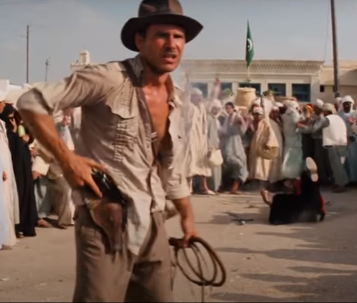 Indiana Jones shoots a scimitar-wielding brute