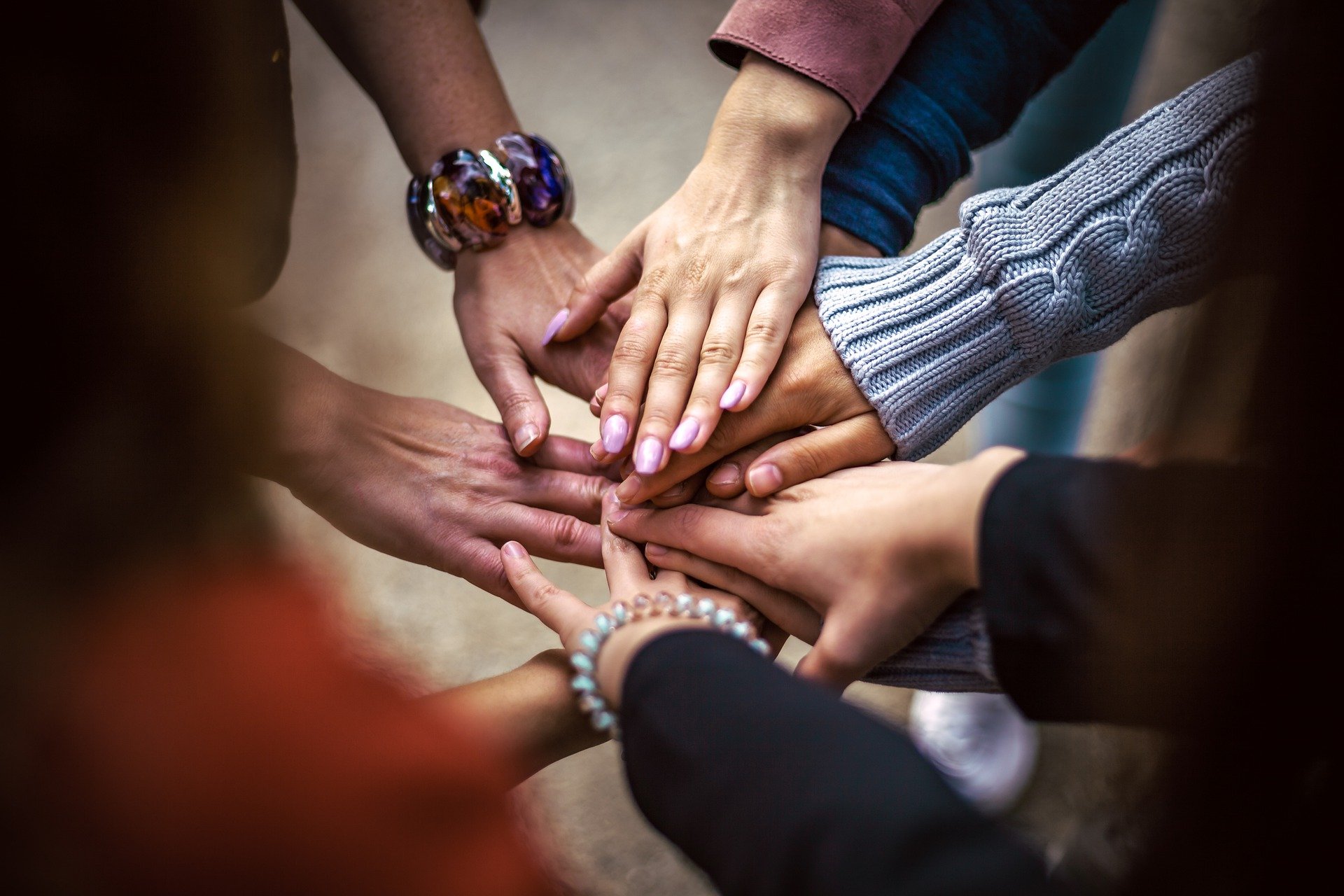 A group of people extending their hands and their hands touch.