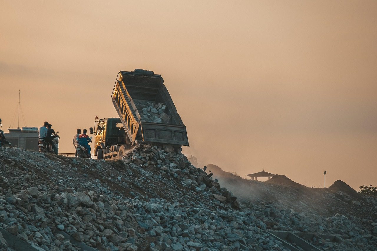 A garbage truck dumping its contents into a landfill.