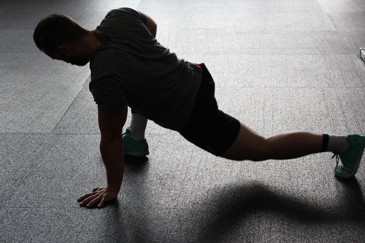 A man on the ground doing a stretch, before a workout or run.