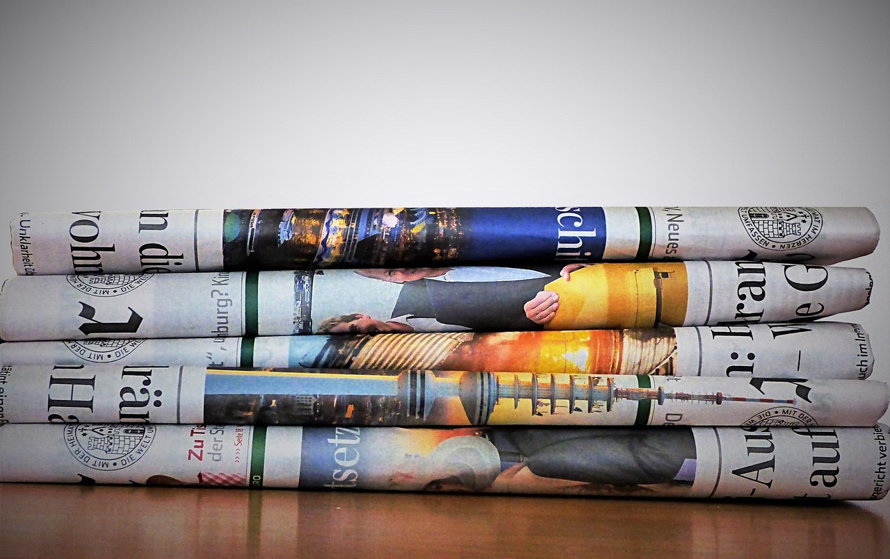A stack of folded newspapers on a table.